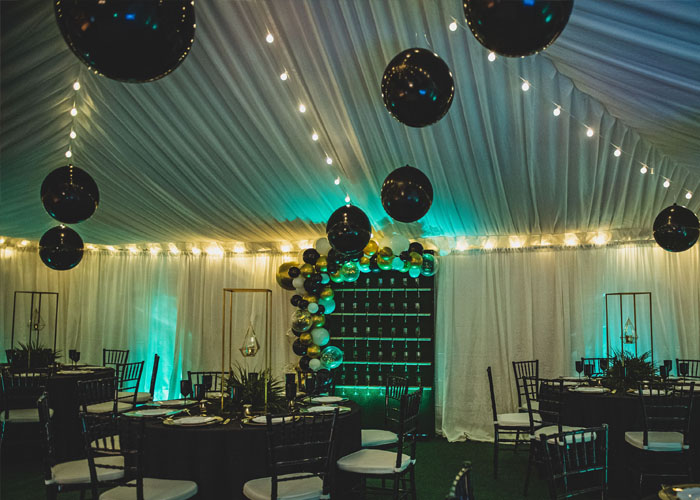 a dining table set up under a wedding tent